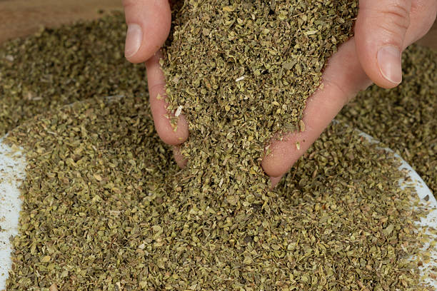 istock Dried natural oregano pouring from hands, close-up 2223659109