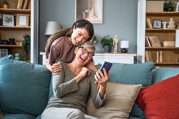 istock Mother and daughter laughing together while using a smartphone at home 2223665207