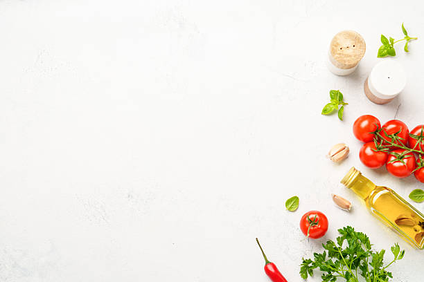 istock Spices, herbs and vegetables with olive oil on white kitchen table. 2223665540