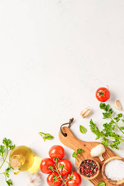 istock Spices, herbs and vegetables with olive oil on white kitchen table. 2223665552