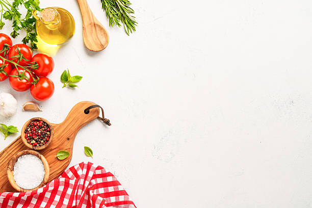 istock Spices, herbs and vegetables with olive oil on white kitchen table. 2223665556