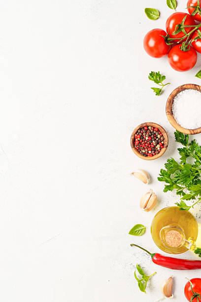 istock Spices, herbs and vegetables with olive oil on white kitchen table. 2223665620