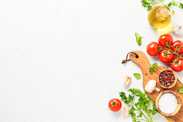 istock Spices, herbs and vegetables with olive oil on white kitchen table. 2223665626