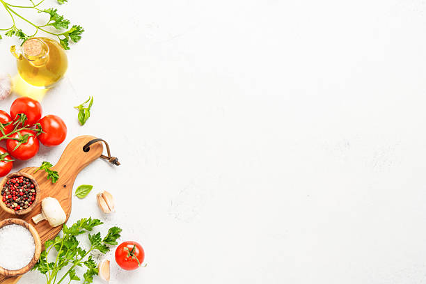 istock Spices, herbs and vegetables with olive oil on white kitchen table. 2223665710