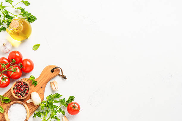 istock Spices, herbs and vegetables with olive oil on a white kitchen table. Flat lay image with copy space. 2223665714