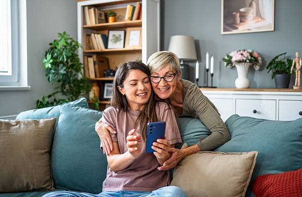 istock Mother and daughter sharing a moment of joy while using a smartphone at home 2223665786