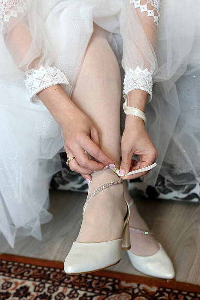 istock The bride's friend helps her put on her shoes. 2223666392