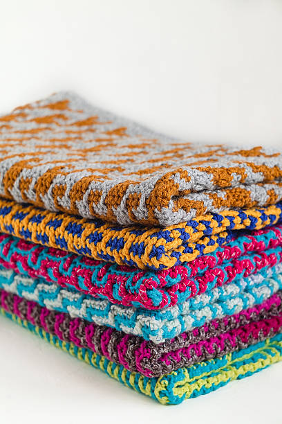 istock Stack of bright crochet clothes with ethnic geometric pattern on a white background. Copy space. 2223667161