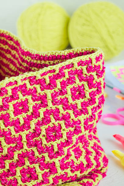 Bright pink yellow crochet geometric pattern close up. Modern needlework concept.