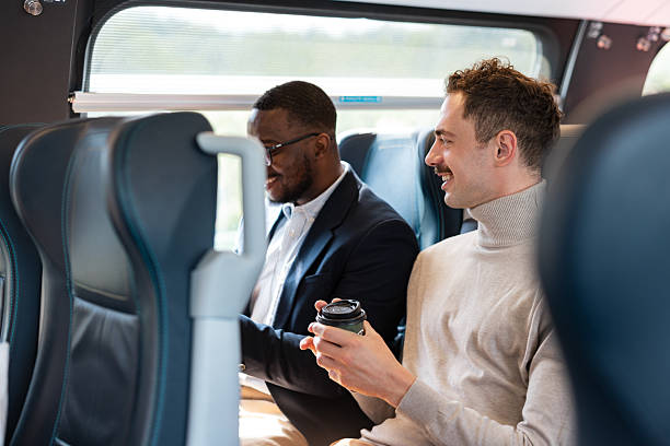 istock Two colleagues conversing and smiling on a commuter train during business travel 2223667318