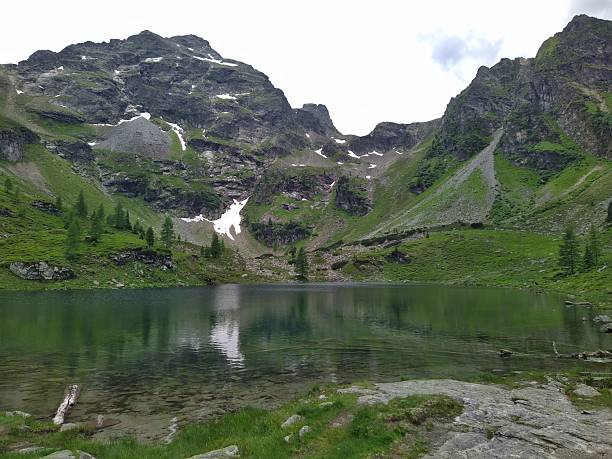 istock Alpine Lake with Snow-Capped Peaks and Reflections 2223675758
