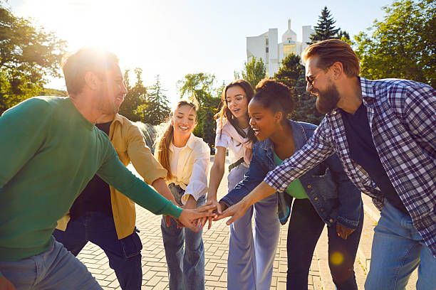 istock Group friendly young multinational of people standing in circle stretching out hand forward outdoor 2223679510
