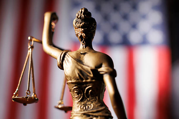 istock Lady Justice's back in front of American flag 2223683505