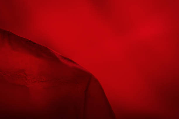 Extreme close up of red empty plastic bag background. The plastic surface is wrinkly and tattered making abstract pattern. Selective focus, shallow depth of field.