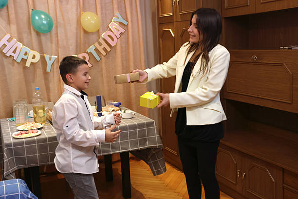 Boy receives birthday presents. Soft lighting.