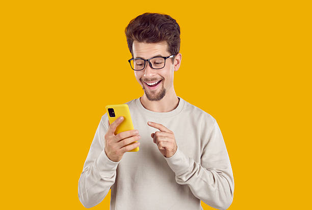 istock Happy smiling young man in glasses looking at message or notification on mobile phone 2223685958