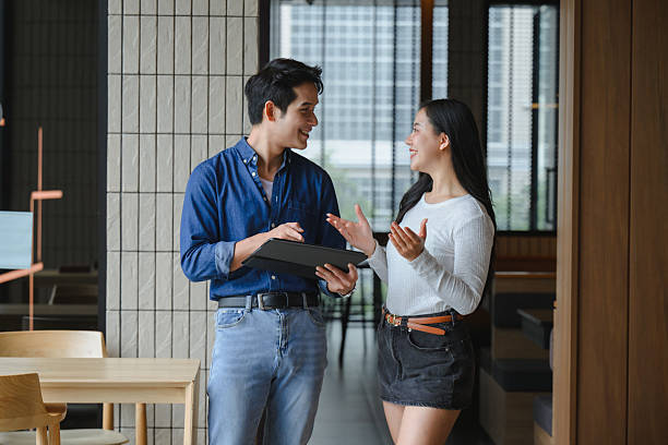 istock Two young asian professionals are discussing a project using a tablet in a modern office, smiling and collaborating effectively 2223688889