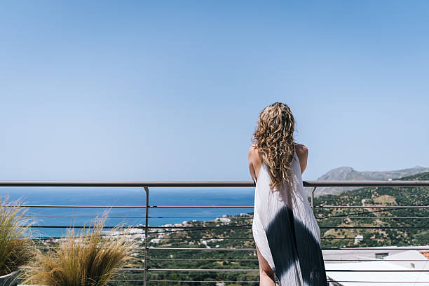 istock Woman looks over railing to distant sea 2223696115