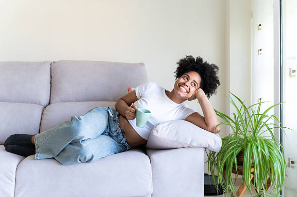 istock Woman relaxing on sofa with coffee 2223696584