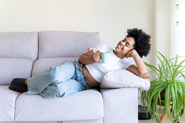 istock Woman relaxing on sofa with a cup of coffee 2223696613