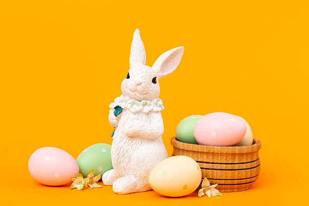 istock Easter bunny with painted eggs on color background 2223697953