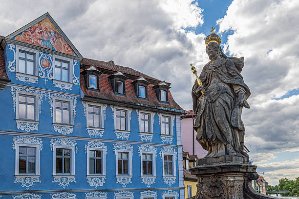 Bamberg, Bavaria: Saint Empress Kunigunde statue (Statue der Heiligen Kaiserin Kunigunde) or Kunigunde von Luxemburg sculpted by J.P. Benkert in 1750, with Heller Haus (Blue House).