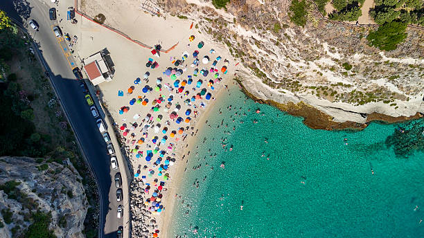 istock Tropea beach seen from above with sunbathers, umbrellas, and waves on a hot day 2223714073