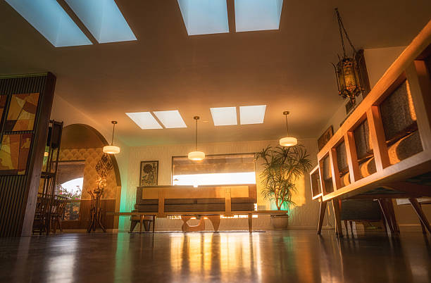 A glowing midcentury modern living room with skylights, vintage furniture, lush plant life, and warm tones—perfect for lifestyle, design, or architectural shoots.