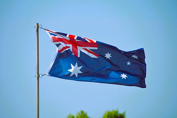 istock The Australian Flag against a clear blue sky. 2223715566