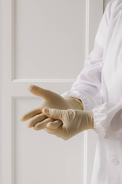 istock Mature nurse putting on sterile gloves. 2223716530
