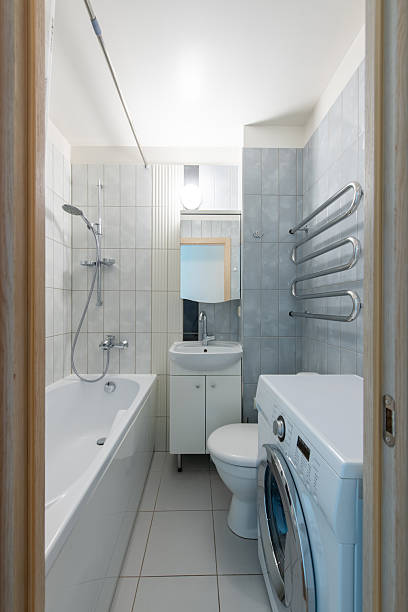 istock Modern Small Bathroom with Bathtub, Washing Machine, and Tiled Interior 2223722437