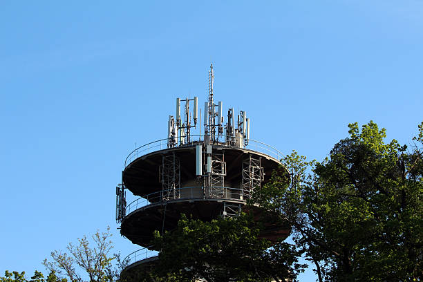 istock Telecommunications tower with multiple antennas above treetops 2223730612