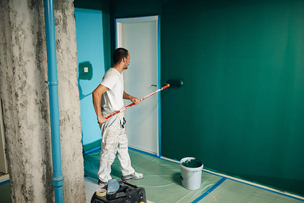 painter painting a wall with a paint roller in a room being renovated - målare bildbanksfoton och bilder