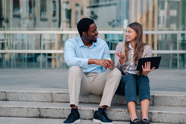 istock Business partners discussing a project using a tablet and drinking coffee outdoors 2223733434