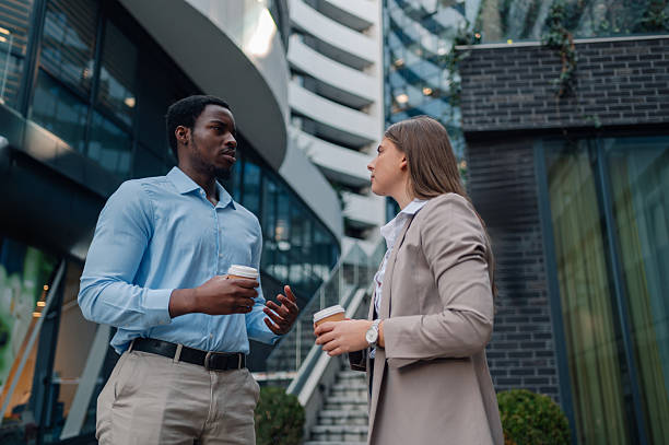 istock Business partners discussing during coffee break in front of modern office buildings 2223733459