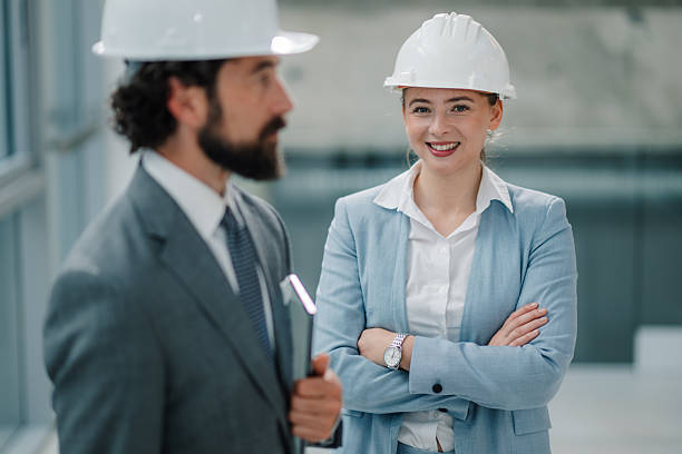 istock Smiling architects wearing hard hats discussing a project 2223733666