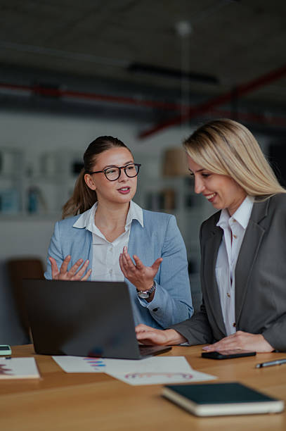 istock Businesswomen collaborating on project using laptop in office 2223733702