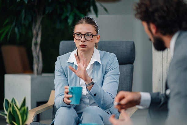 istock Businesswoman gesturing while talking to colleagues during coffee break 2223733743