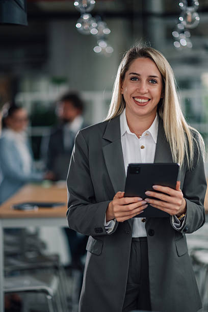 istock Smiling businesswoman holding digital tablet in modern office 2223733748