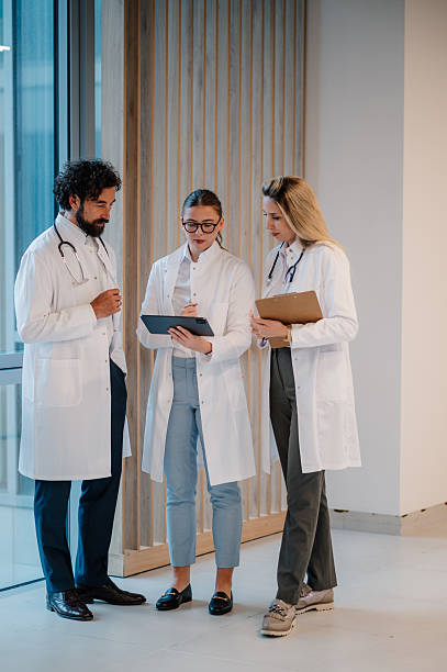 istock Doctors discussing patient data using digital tablet in hospital corridor 2223733870
