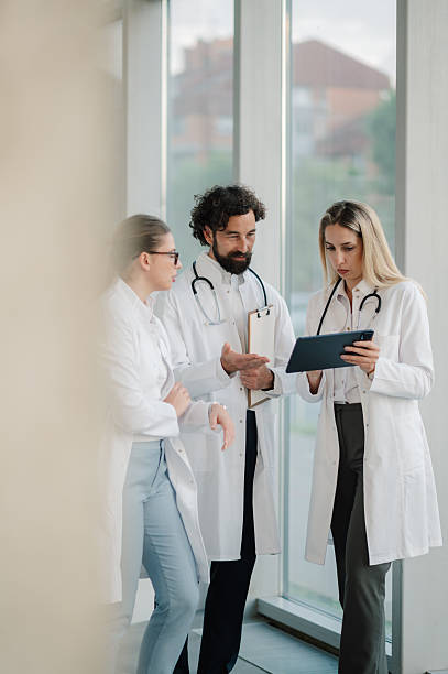 istock Doctors discussing patient data using digital tablet and clipboard in hospital 2223733900