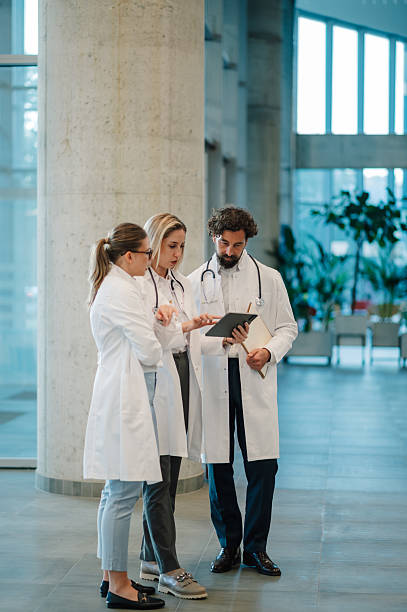 istock Doctors using tablet and discussing diagnosis in hospital hallway 2223733904