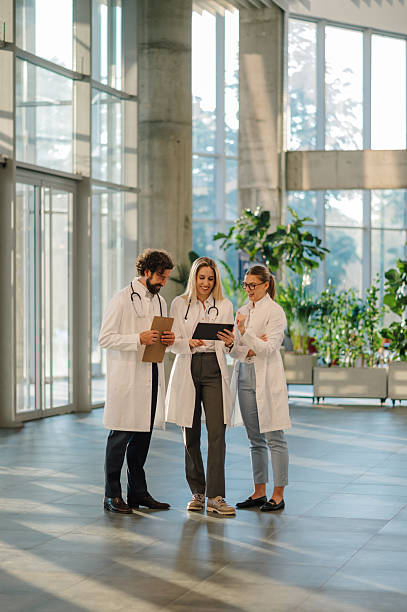 istock Doctors consulting using digital tablet in hospital lobby 2223733911