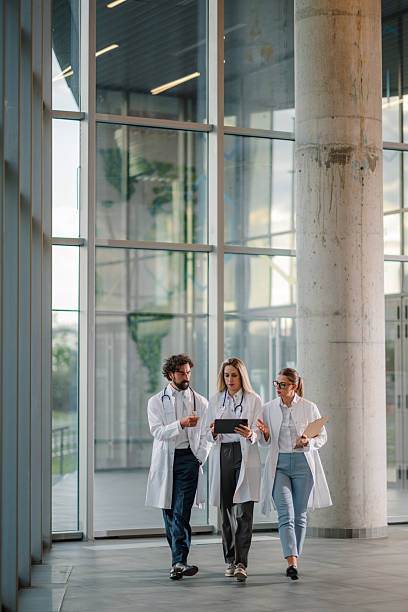 istock Doctors walking and discussing over digital tablet in hospital corridor 2223733951