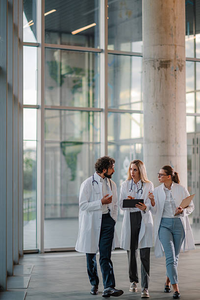 istock Doctors walking and discussing diagnosis in hospital hallway 2223733956