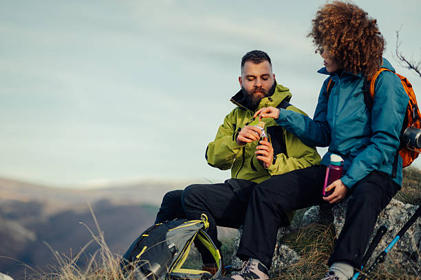 istock Hikers resting and eating energy bars on mountain top 2223734350