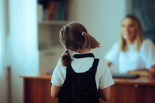 istock Shy Student Looking at her Teacher Feeling Anxious to Answer 2223734408