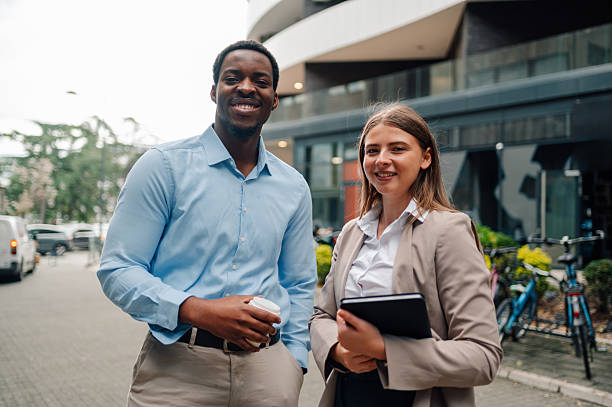 istock Smiling business people standing outside office building 2223734634