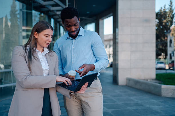 istock Business colleagues collaborating on laptop outside office building 2223734659