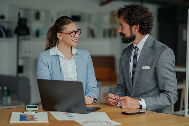 istock Business colleagues discussing work at office desk with laptop 2223734770